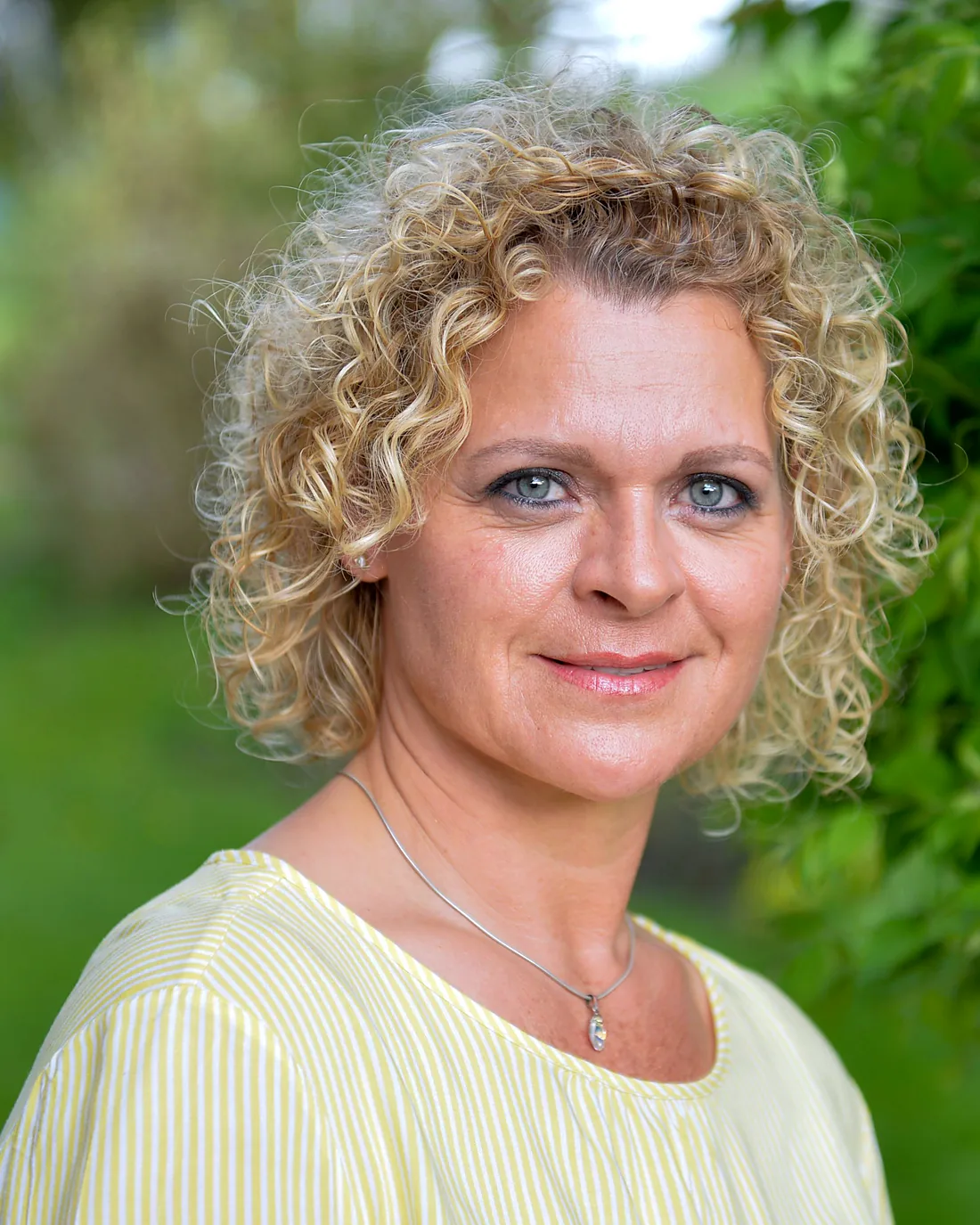 Porträt von Claudia Michel im Grünen